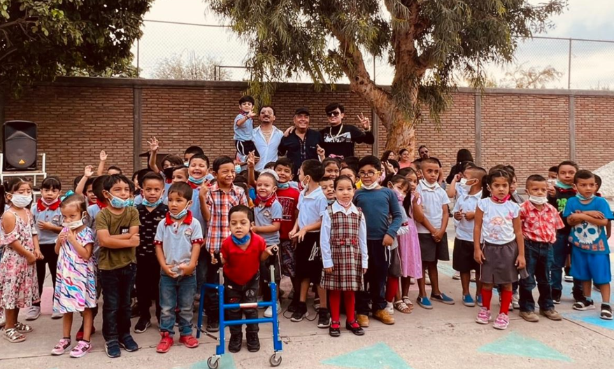 Los Dos Carnales se toman la foto del recuerdo con los alumnos del kínder.